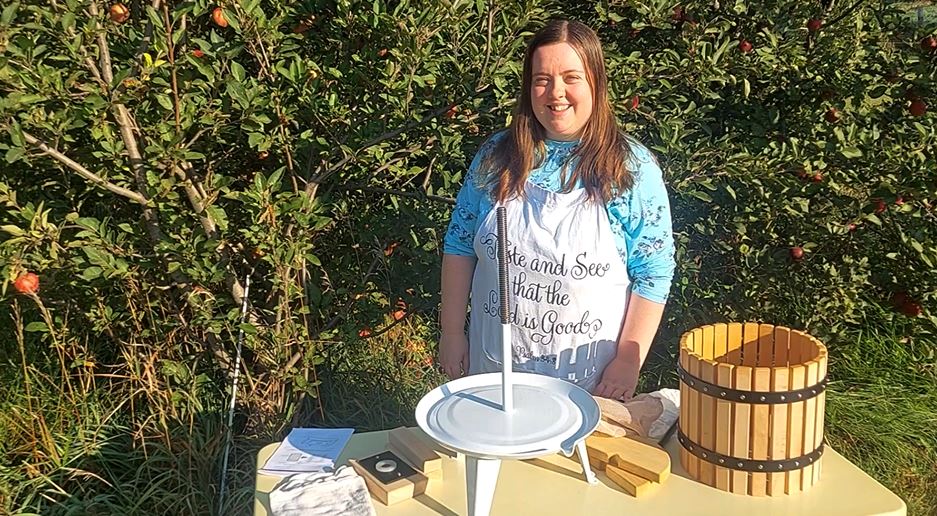 Rachel showing how to use a cider press.